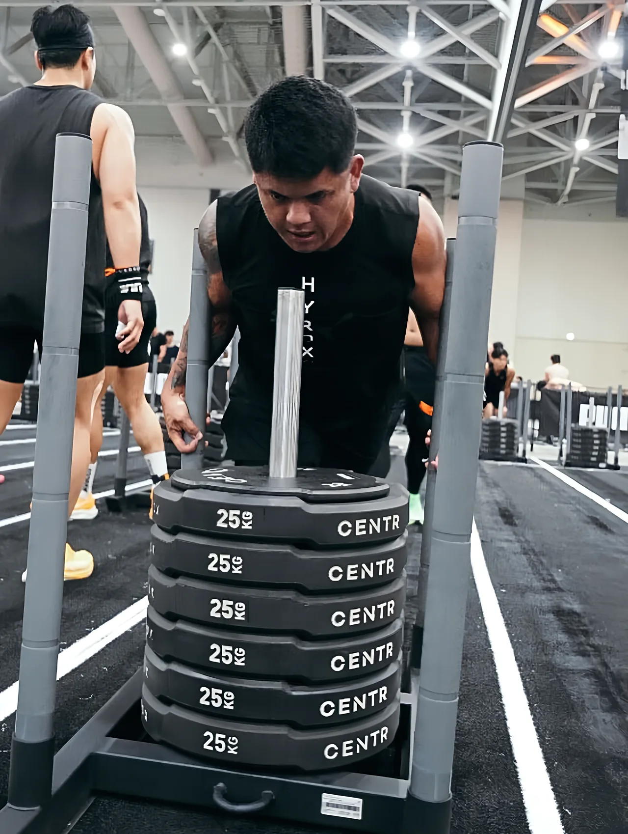 Ac pushing a weighted sled at a HYROX race